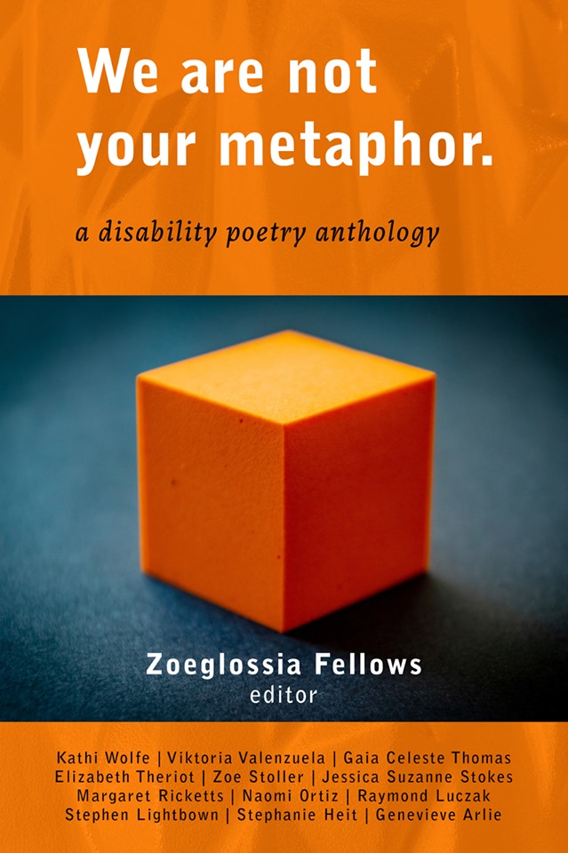 An orange cube, lit from behind, rests on a dark grey surface.